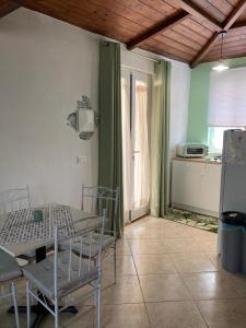 a room with a table and chairs and a kitchen at L'Ulivo in Formia