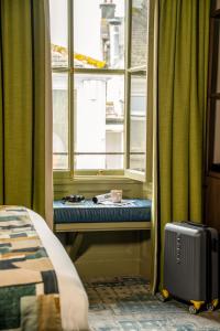 a window seat in front of a window with a suitcase at Royal Oak at Keswick in Keswick