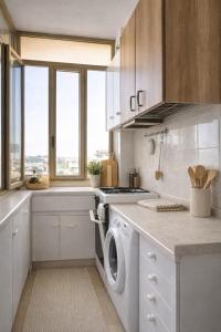 a white kitchen with a washing machine in it at Dimora del Sole in Vasto