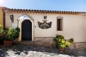 a building with a sign on the side of it at Borgo Medievale in Castelmola