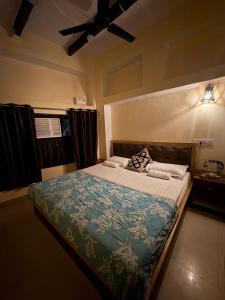 a bed in a bedroom with a ceiling fan at Stay in Someshwar in Varanasi +9 photos