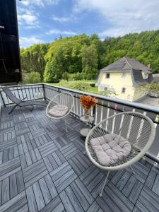 a deck with two chairs and a vase on it at Hiša Čebron in Podnart