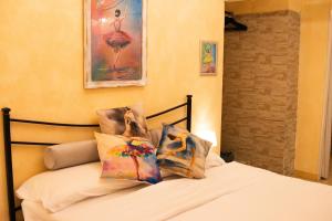 a bedroom with a bed with pillows on it at Domus Mazzini in Tivoli