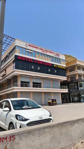 a white car parked in front of a building at Hotel Fortune in Ankleshwar