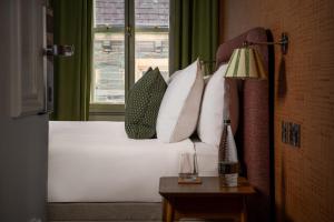 a bedroom with a bed with white pillows and a window at Royal Oak at Keswick in Keswick