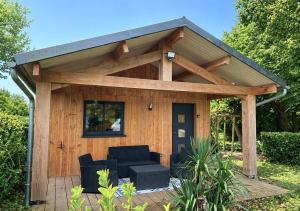 a wooden pergola with a couch in front of it at Chez mathilde et sÉbastien in Rubigny