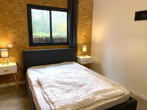 a bedroom with a bed with two night stands and a window at Chez mathilde et sÉbastien in Rubigny