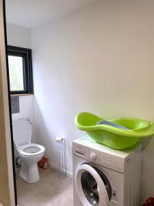 a washing machine with a green bowl on top of it at Chez mathilde et sÉbastien in Rubigny +13 photos