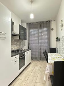 a kitchen with white cabinets and a table with a counter top at Venice Night 11 in Mestre