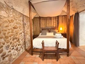 a bedroom with a bed in a stone wall at VentallóLEscala. WiFi. Rooftop w stunning views in Ventalló