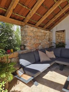 a living room with a blue couch under a stone wall at Mai's Cottage in Stari Grad