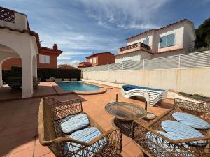 a patio with chairs and a swimming pool at Villa Riells Mar in L'Escala