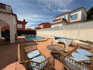 a patio with two chairs and a swimming pool at Villa Riells Mar in L'Escala
