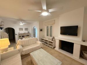 a living room with a couch and a flat screen tv at Villa Riells Mar in L'Escala