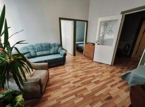 a living room with a blue couch and a wooden floor at Hostel Lõuna in Pärnu