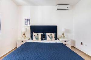 a bedroom with a blue bed with two night stands at Condo Cabrinha - Kite Beach Cabarete in Cabarete