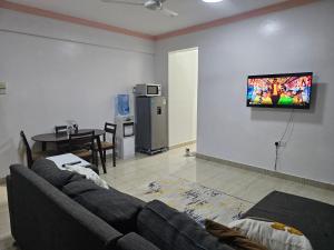 a living room with a couch and a television on a wall at Kim'sPlace in Mombasa