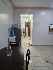 a dining room with a table and a kitchen at Kim'sPlace in Mombasa