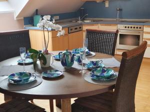 a wooden table with plates and glasses on it in a kitchen at Ferienwohnung Wiener in Marchtring