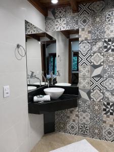a bathroom with two sinks and a mirror at Refúgios de Mauá - Chalé Serra in Visconde De Maua