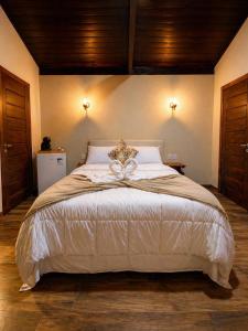 a bedroom with a large bed with a bow on it at Refúgios de Mauá - Chalé Serra in Visconde De Maua