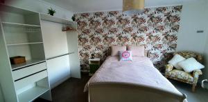 a small bedroom with a bed with a pink box on it at Maison des Roses in Béalencourt +19 photos
