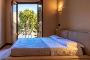 a bedroom with a bed with a view of a patio at Baglio Làuria in Campobello di Licata