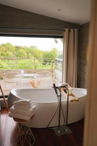 a bath tub in a room with a balcony at Carrière Sauvage in Pont-Aven
