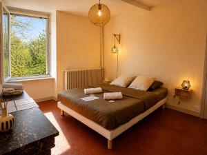 a bedroom with a bed and a large window at Chambre d'hôtes Les Berges de l'Aude - B&B - Proche Canal du midi & Carcassonne in Puicheric