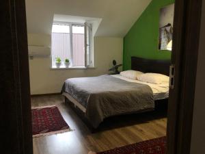 a bedroom with a bed and a green wall at Secret Garden in Dushanbe