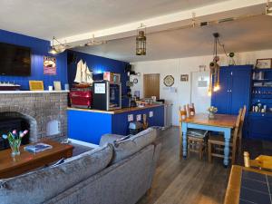a living room with blue walls and a table and a couch at The Seafront Inn Holyhead in Holyhead