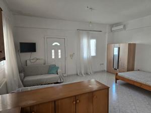 a living room with a couch and a tv at Nature & Sea Paradise in Analipsi in Análipsis