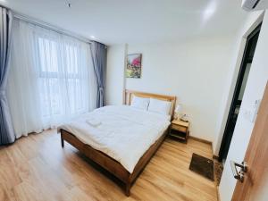a bedroom with a bed and a large window at Rose Home in Lao Cai