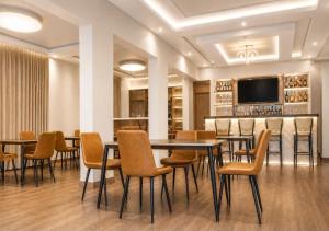 a dining room with tables and chairs and a bar at Cape Town K Hotel in Kigali