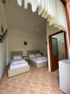 a bedroom with two beds and a mirror at Guesthouse SELI in Berat