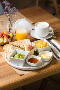 a plate of breakfast food on a wooden table at Mahia hotel Reñaca in Viña del Mar