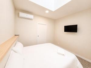 a bedroom with a bed and a tv on the wall at Hostal Majadahonda in Majadahonda