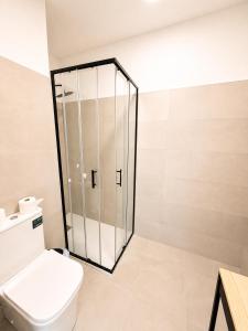 a bathroom with a toilet and a glass shower at Hostal Majadahonda in Majadahonda