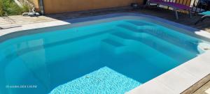 a large swimming pool with blue water at La Casa Liberta in Salavas
