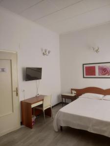 a bedroom with a bed and a desk and a television at Affittacamere La Spezia Inn in La Spezia