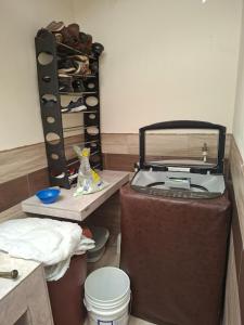 a room with a sewing machine and a shelf of shoes at San Martin in Ibarra