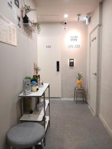a hallway with a waiting room with two stools at Hotel Soda STAY in Seoul