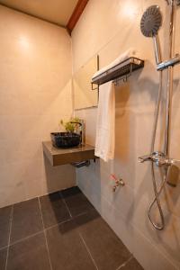 a bathroom with a shower with a towel and a shower head at Dreamy Homestay in Xuân Sơn