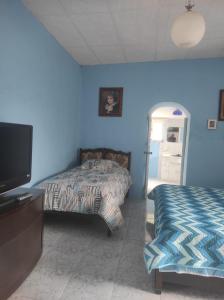 a bedroom with two beds and a flat screen tv at Quinta 4 esquinas cerca de Chachimbiro in Hacienda San Clemente