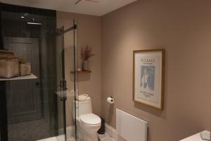 a bathroom with a toilet and a glass shower at Studio 27 in Magog-Orford +18 photos