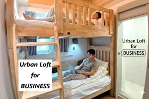 a man sitting in a bunk bed with the words urban loft for business at Hotel Soda STAY in Seoul