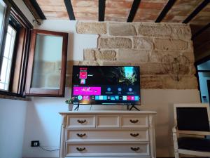 a flat screen tv sitting on top of a dresser at Almarè Confort Rooms in Terrasini