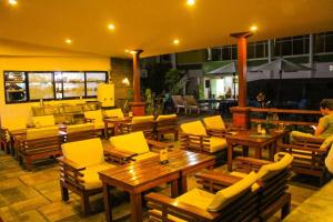 a restaurant with wooden tables and yellow chairs at Woodland Heritage Hotel in Kathmandu