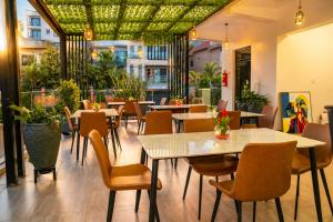 a restaurant with tables and chairs and windows at Cape Town K Hotel in Kigali