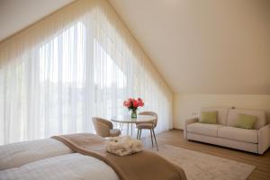a bedroom with a bed and a table and a couch at Kálló Villa in Nagykálló +54 photos